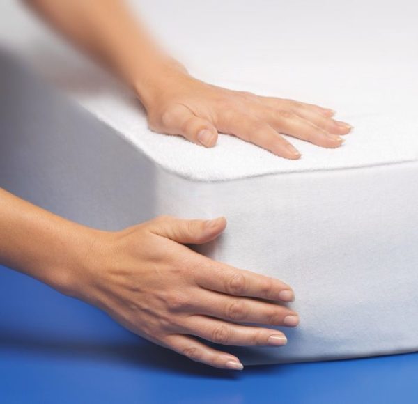 hands fitting the mattress protector